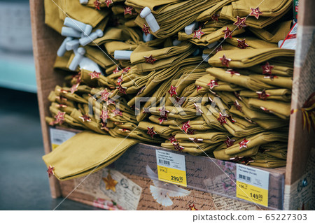 Stack of military caps of the Soviet army with red stars in supermarket. Garrison cap with a red stars. Red stars with sickle and hammer. 65227303
