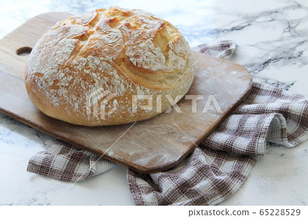 Freshly baked homemade crisp bread on rustic wooden board on a linen napkin 65228529