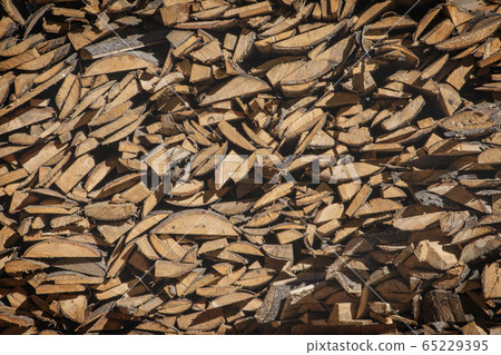 A pile of firewood, firewood wall of an old wooden house, preparation of firewood for the winter. 65229395