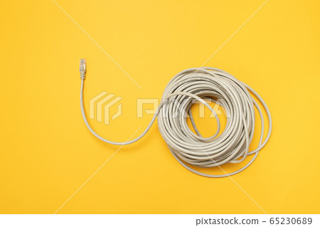 Closeup RJ45 Network internet cable hank on a yellow background. Concept, flat lay Closeup RJ45 Network internet cable hank on a yellow background. Concept, flat lay 65230689
