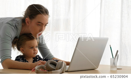 Mother and little daughter using laptop at home Mother and little daughter using laptop at home 65230904