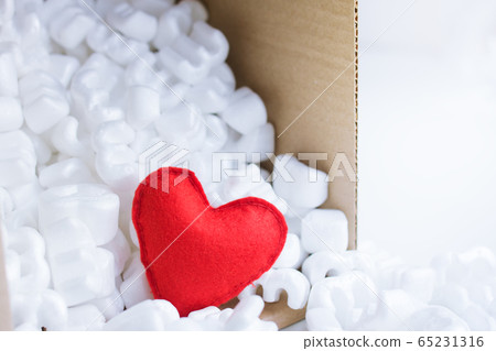 Red felt heart packaging box filled many white styrofoam pellets. Red felt heart packaging box filled many white styrofoam pellets. 65231316