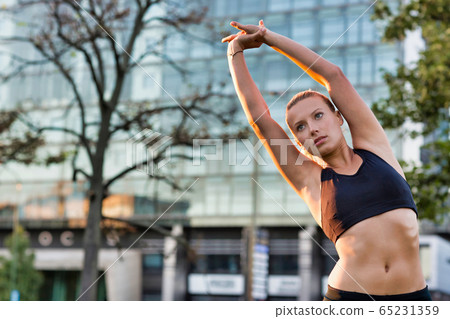 Portrait of young attractive woman stretching in 65231359