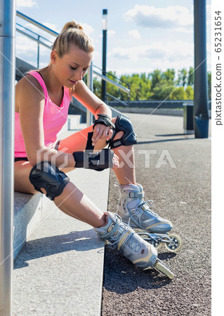 Young attractive woman adjusting safety gear while 65231654