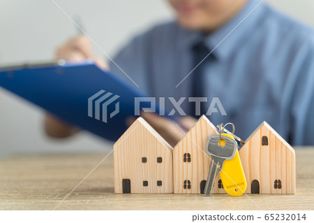 House Wooden model and Key in real estate , seller or buyer , loan concept with blur loan employee or realtor he's checking details about the sale of the house ,home Mortgage or home lone House Wooden model and Key in real estate , seller or buyer , loan concept with blur loan employee or realtor he's checking details about the sale of the house ,home Mortgage or home lone 65232014