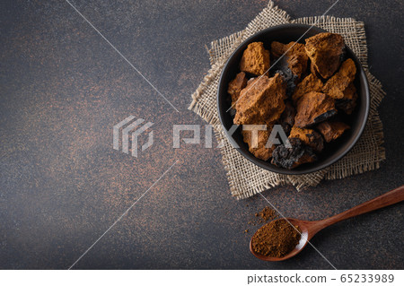 Chaga birch Mushrooms in bowl on black table. Chaga birch Mushrooms in bowl on black table. 65233989