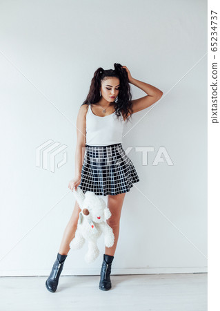 Beautiful fashionable brunette woman in a skirt with toy bear 65234737