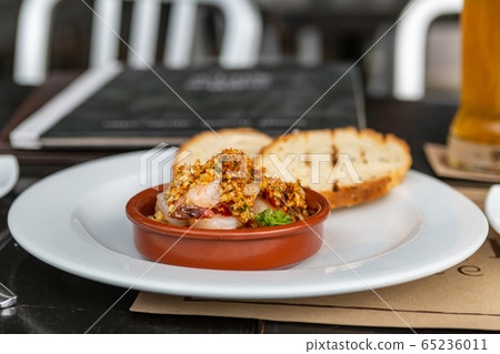 Creole shrimp Gremolata lies in a clay plate amid 65236011
