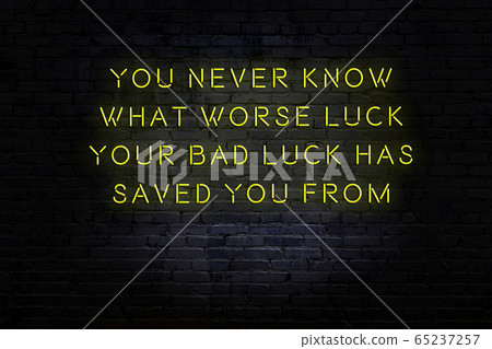 Wise quote. Neon inscription against brick wall Wise quote. Neon inscription against brick wall 65237257