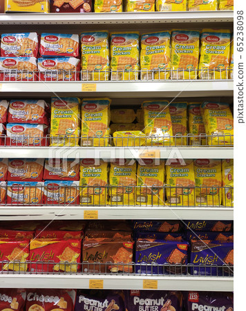 Variety of biscuits in good and interesting packaging and displayed on the racks inside the shop. Sort by brand and type to make it easier for customers to buy. 65238098