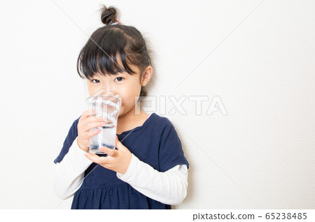 Smiling girl drinking water in a cup Smiling girl drinking water in a cup 65238485