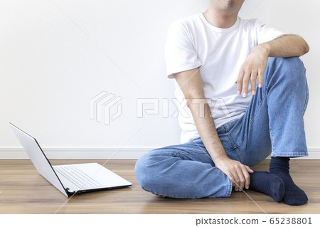 Man sitting on the floor and using laptop 65238801