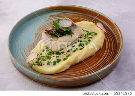 Cod with mashed potatoes, zucchini grill and sauce on the light background. European cuisine. The 65241570