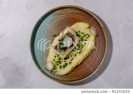 Cod with mashed potatoes, zucchini grill and sauce on the light background. European cuisine. The Cod with mashed potatoes, zucchini grill and sauce on the light background. European cuisine. The 65241650