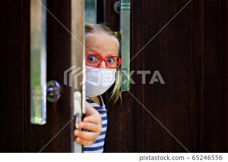 Child wearing face masks peeking out the door 65246556