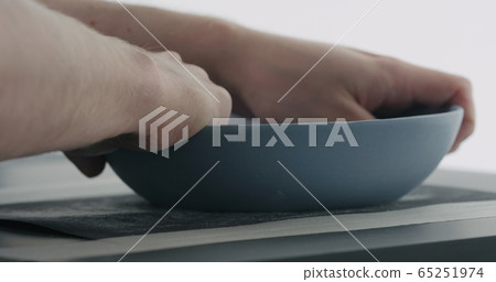 man hands sand bottom of blue ceramic bowl man hands sand bottom of blue ceramic bowl 65251974