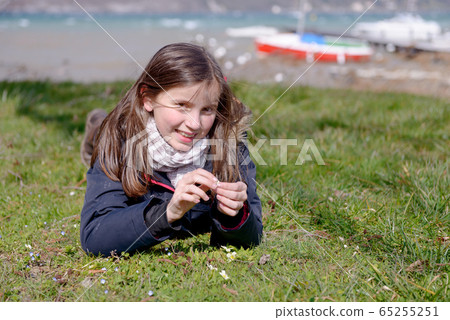 pretty preteen is lying in the green grass 65255251