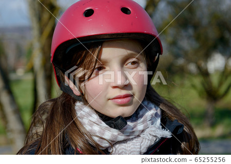 Teenage girl wearing a roller skate helmet. Teenage girl wearing a roller skate helmet. 65255256