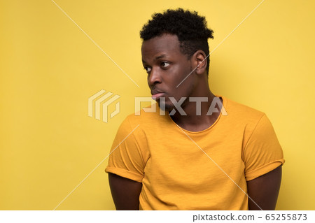 Young african american man looking down with guilty confused expression Young african american man looking down with guilty confused expression 65255873