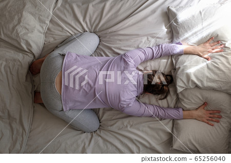 caucasian woman working out at home doing Child pose, Balasana on the bed. 65256040