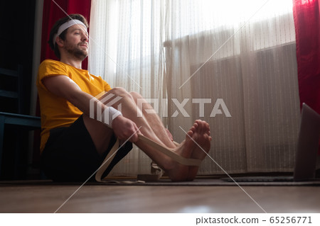 Young man sitting in paschimottanasana or Intense Dorsal Stretch pose Young man sitting in paschimottanasana or Intense Dorsal Stretch pose 65256771