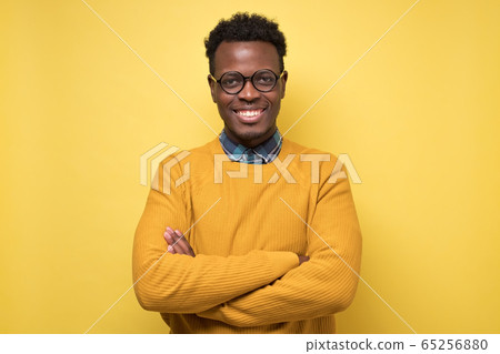 Smiling young african american man with glasses smiling confident 65256880