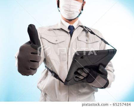 工人戴著平板設備和口罩（豎起大拇指） 65257484