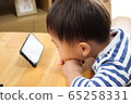 Infant watching a smartphone 65258331