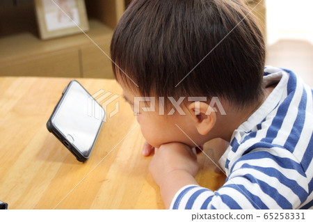 Infant watching a smartphone 65258331