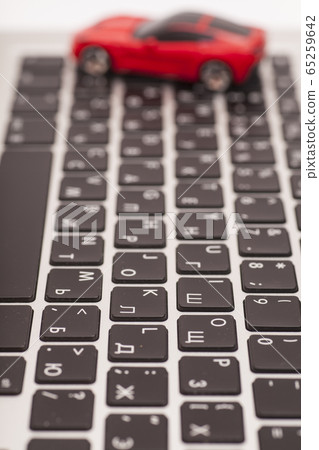Toy car over laptop keyboard 65259642