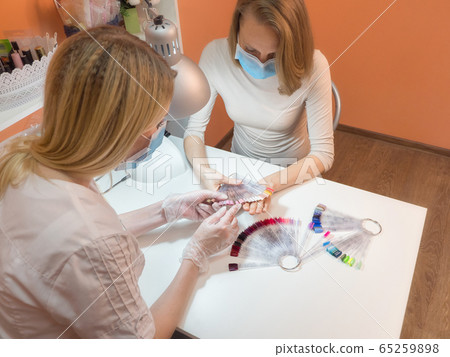 The manicure process. Work in a medical mask 65259898