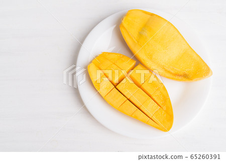 Ripe mango fruit sliced to cubes on white plate ready to eating, Tropical fruit, Thai mango (Nam Dok Mai), Top view 65260391