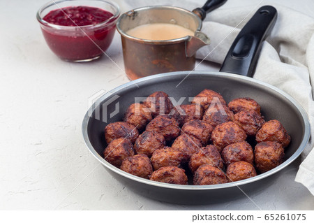 Meatballs served with cream sauce and cranberry 65261075