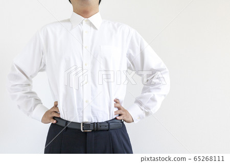 A man wearing a shirt, with his hands on his waist and his chest A man wearing a shirt, with his hands on his waist and his chest 65268111