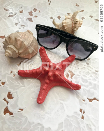 A beautiful red starfish and black sunglasses A beautiful red starfish and black sunglasses 65269796