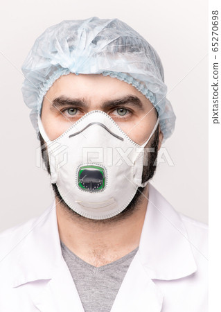 Serious surgeon or doctor in medical cap, protective eyeglasses and respirator Serious surgeon or doctor in medical cap, protective eyeglasses and respirator 65270698