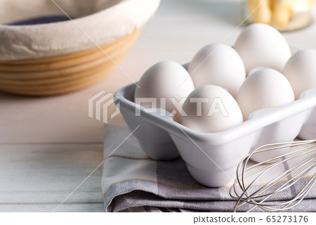 Ceramic container with natural organic farm eggs on a blurred kitchen background. Ceramic container with natural organic farm eggs on a blurred kitchen background. 65273176