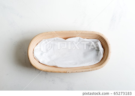 Handmade wicker basket for homemade freshly baked pastry on a light grey marble background. 65273183