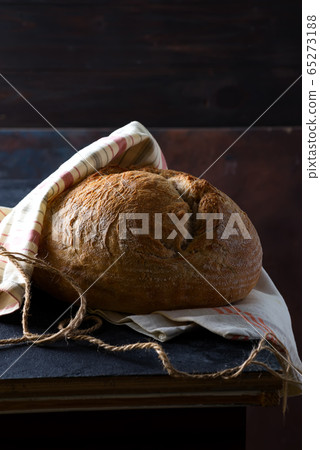 Freshly baked homemade rye bread decorated textile towel on a dark stone table. Freshly baked homemade rye bread decorated textile towel on a dark stone table. 65273188