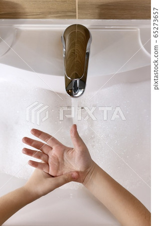 The child looks at the washed clean hands. Above The child looks at the washed clean hands. Above 65273657