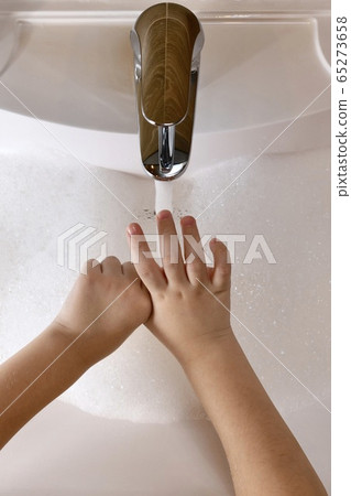 The child learns to wash the thumb area, with The child learns to wash the thumb area, with 65273658