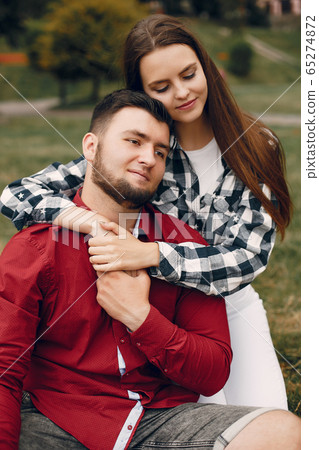 Beautiful couple spend time in a summer park Beautiful couple spend time in a summer park 65274872