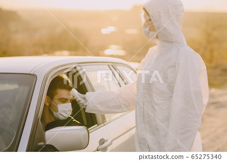 Person in a protective suit checks the temperature 65275340