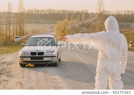 Person in a protective suit checks the temperature Person in a protective suit checks the temperature 65275361