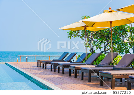 Beautiful empty chair umbrella around outdoor swimming pool in hotel resort for travel Beautiful empty chair umbrella around outdoor swimming pool in hotel resort for travel 65277230