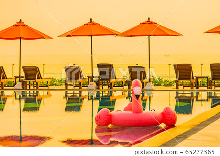 Beautiful sunrise around with umbrella and chair outdoor swimming pool Beautiful sunrise around with umbrella and chair outdoor swimming pool 65277365