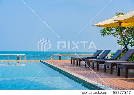 Beautiful empty chair umbrella around outdoor swimming pool in hotel resort for travel Beautiful empty chair umbrella around outdoor swimming pool in hotel resort for travel 65277547