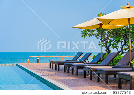 Beautiful empty chair umbrella around outdoor swimming pool in hotel resort for travel Beautiful empty chair umbrella around outdoor swimming pool in hotel resort for travel 65277548