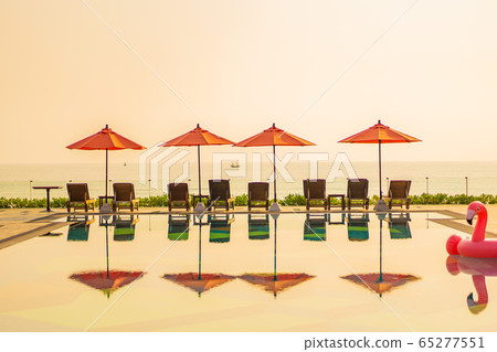 Beautiful sunrise around with umbrella and chair outdoor swimming pool Beautiful sunrise around with umbrella and chair outdoor swimming pool 65277551