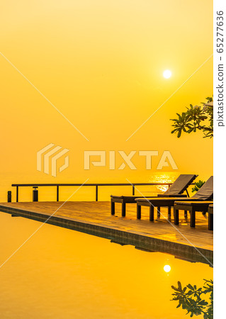 Beautiful sunrise around with umbrella and chair outdoor swimming pool 65277636